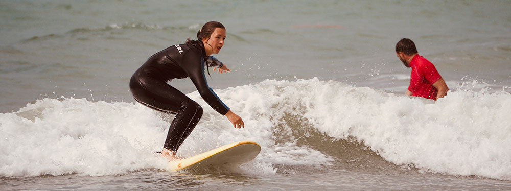 Frau hat Spaß beim Wellenreiten in kleinen Wellen
