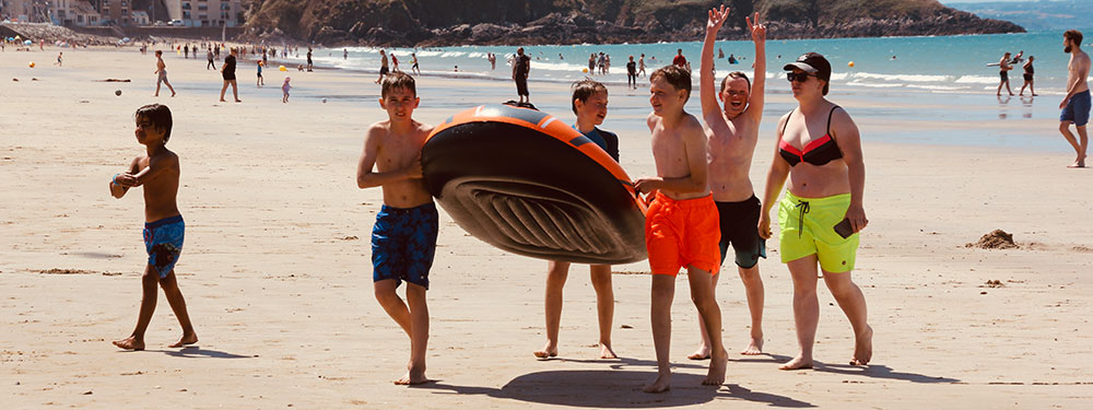 Kinder gehen mit Wasserspielzeug zum Strand